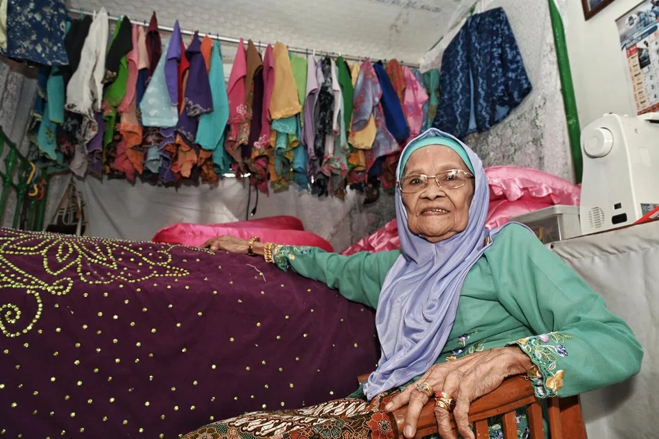Cik Juhara Abdul Rahib, 98 tahun, menggantung koleksi baju jahitannya sendiri dalam bilik tidur. 