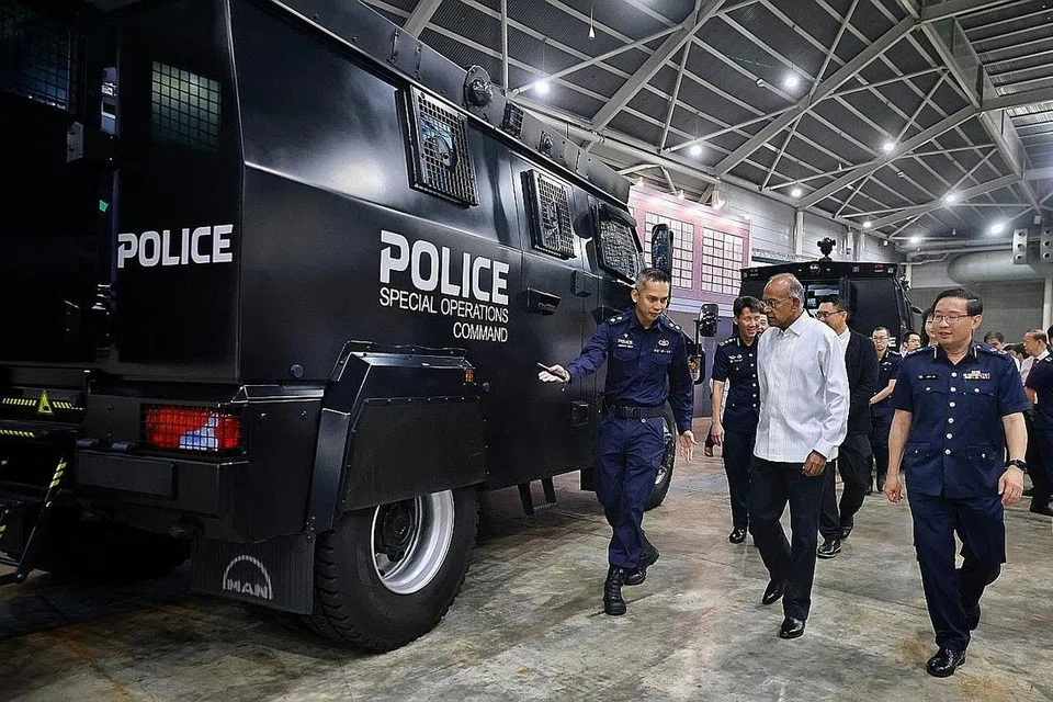 KEUPAYAAN POLIS: Menteri Ehwal Dalam Negeri merangkap Undang-undang, Encik K. Shanmugam (berbaju putih) ditemani Pemangku Pesuruhjaya Polis, Encik Jerry See (kanan) semasa meninjau kenderaan serangan taktikal di Pameran dan Seminar Pelan Kerja Polis di Singapore Expo pada Jumaat. - Foto-foto ST