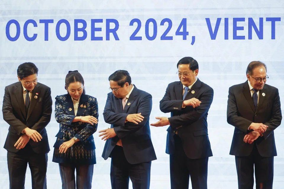 Perdana Menteri Singapura, Encik Lawrence Wong; Perdana Menteri Thailand, Cik Paetongtarn Shinawatra; Perdana Menteri Vietnam, Encik Pham Minh Chinh; Perdana Menteri Laos, Encik Sonexay Siphandone; dan Perdana Menteri Malaysia, Encik Anwar Ibrahim; mencapai tangan masing-masing untuk bergambar bersama semasa Sidang Pleno Sidang Kemuncak Asean ke-44 di Pusat Konvensyen Nasional di Vientiane, Laos, pada Oktober 2024.