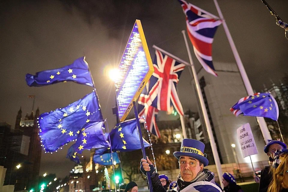 LAKUKAN BANTAHAN: Penentang Brexit memegang sepanduk dan bendera Britain serta EU di luar kawasan bangunan Parlimen di London, Britain. - Foto Reuters