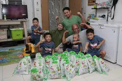SAMBUTAN HARI LAHIR DALAM TEMPOH 'P2HA': Encik Jamil Hamid dan isteri, Cik Hesty Pratiwi, serta anak mereka Adnan Apriandanu, 15 tahun (berbaju hijau), pasangan kembar Haikal (dua dari kiri) dan Haidar (paling kanan), lapan tahun, Syauqi Ramadhan, empat tahun (paling kiri) dan Abizar Maulana, tiga tahun (duduk di pangkuan), membungkus 'goodie bag' yang diberikan kepada rakan Syauqi di sekolah Jumaat lalu sempena sambutan ulang tahunnya. Sambutan ulang tahun kali ini hanya dapat dibuat di rumah sahaja akibat keterbatasan dek langkah selamat semasa tempoh Fasa Dua (Kewaspadaan Diperketat). - Foto BM oleh GIN TAY