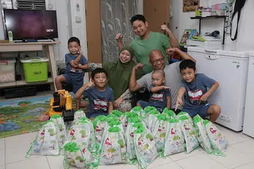 SAMBUTAN HARI LAHIR DALAM TEMPOH 'P2HA': Encik Jamil Hamid dan isteri, Cik Hesty Pratiwi, serta anak mereka Adnan Apriandanu, 15 tahun (berbaju hijau), pasangan kembar Haikal (dua dari kiri) dan Haidar (paling kanan), lapan tahun, Syauqi Ramadhan, empat tahun (paling kiri) dan Abizar Maulana, tiga tahun (duduk di pangkuan), membungkus 'goodie bag' yang diberikan kepada rakan Syauqi di sekolah Jumaat lalu sempena sambutan ulang tahunnya. Sambutan ulang tahun kali ini hanya dapat dibuat di rumah sahaja akibat keterbatasan dek langkah selamat semasa tempoh Fasa Dua (Kewaspadaan Diperketat). - Foto BM oleh GIN TAY