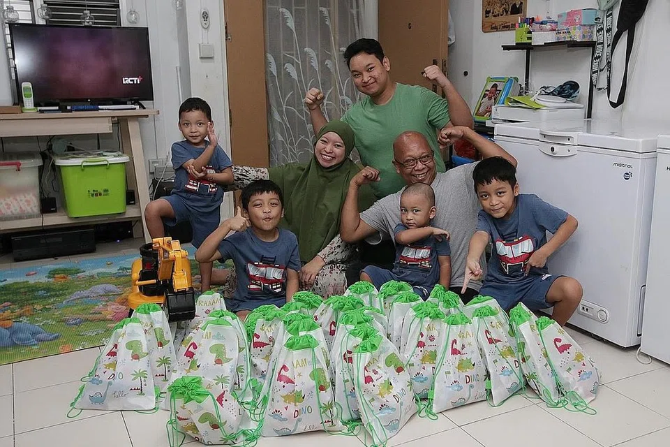 SAMBUTAN HARI LAHIR DALAM TEMPOH 'P2HA': Encik Jamil Hamid dan isteri, Cik Hesty Pratiwi, serta anak mereka Adnan Apriandanu, 15 tahun (berbaju hijau), pasangan kembar Haikal (dua dari kiri) dan Haidar (paling kanan), lapan tahun, Syauqi Ramadhan, empat tahun (paling kiri) dan Abizar Maulana, tiga tahun (duduk di pangkuan), membungkus 'goodie bag' yang diberikan kepada rakan Syauqi di sekolah Jumaat lalu sempena sambutan ulang tahunnya. Sambutan ulang tahun kali ini hanya dapat dibuat di rumah sahaja akibat keterbatasan dek langkah selamat semasa tempoh Fasa Dua (Kewaspadaan Diperketat). - Foto BM oleh GIN TAY