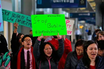 TINDAKAN DIKECAM: Penunjuk perasaan di Lapangan Terbang Antarabangsa O'Hare membantah tindakan kasar United Airlines ke atas seorang penumpang. - Foto AFP