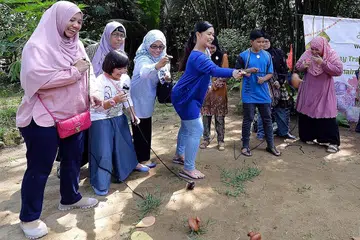TANAH TUMPAH DARAH: Sekumpulan pengunjung cuba bermain gasing semasa lawatan ke Kampung Buangkok. Ada di antara mereka pernah tinggal di kampung tempat tumpah darah di situ beberapa tahun dahulu. - Foto fail