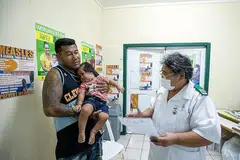 USAHA BENDUNG WABAK: Seorang jururawat Cik Fa'atafa Tavita bercakap bersama sebuah keluarga mengenai suntikan penyakit demam campak di ibu kota Samoa, Apia. Samoa menjalankan pemvaksinan besar-besaran awal bulan ini bagi membendung wabak campak yang membunuh berpuluh-puluh kanak-kanak. - Foto UNICEF
