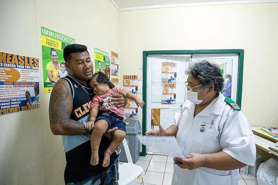 USAHA BENDUNG WABAK: Seorang jururawat Cik Fa'atafa Tavita bercakap bersama sebuah keluarga mengenai suntikan penyakit demam campak di ibu kota Samoa, Apia. Samoa menjalankan pemvaksinan besar-besaran awal bulan ini bagi membendung wabak campak yang membunuh berpuluh-puluh kanak-kanak. - Foto UNICEF