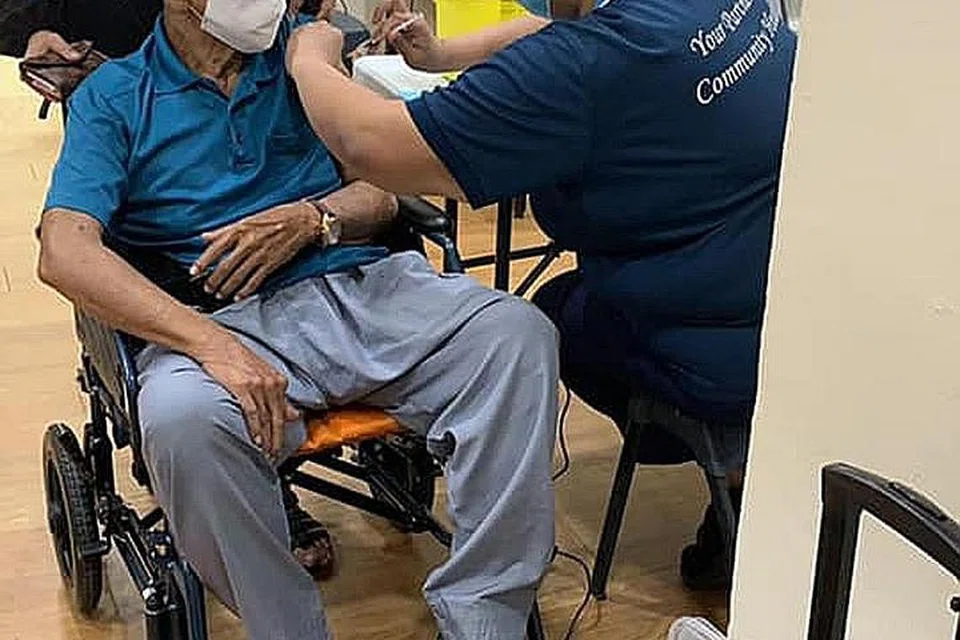 PUSAT VAKSINASI BERGERAK: Warga emas di kawasan West Coast termasuk Encik Mohd Tahir Kassim yang berusia 81 tahun yang ditemani keluarga, mendapatkan dos pertama vaksinasi Covid-19 di pusat vaksinasi bergerak dekat rumah mereka. - Foto ISWARAN FACEBOOK