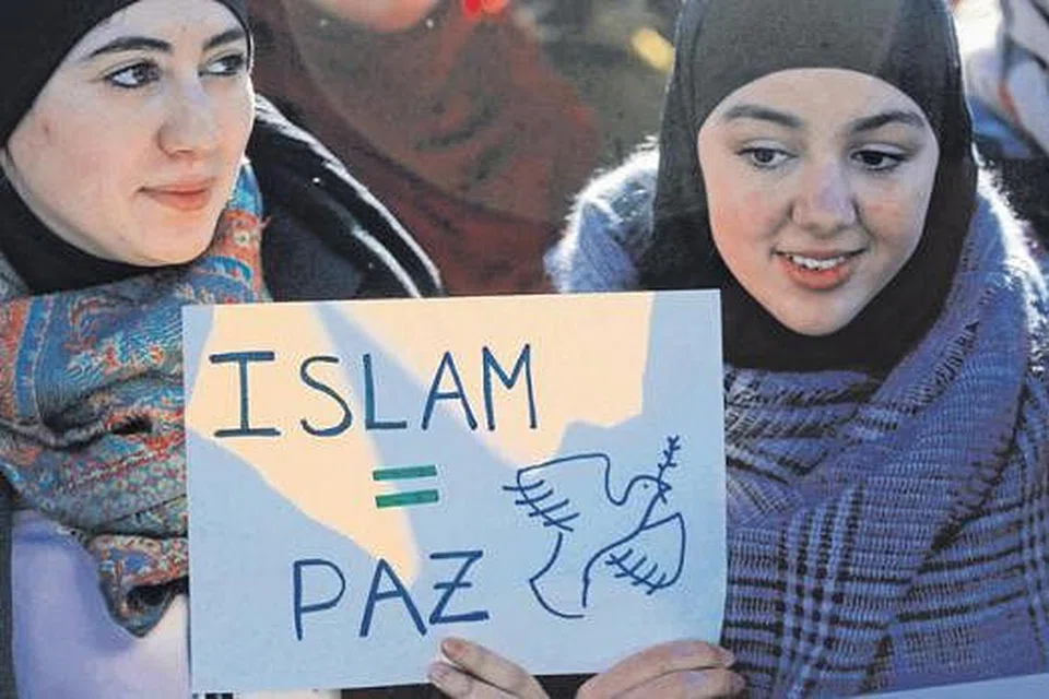ISLAM ITU DAMAI: Dua Muslimah memegang mesej yang bermaksud 'Islam = Keamanan' dalam satu rapat di Madrid, pada 11 Januari lalu. - Foto REUTERS