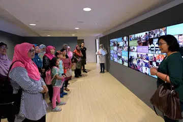 MEMORIAL PENGASAS: Salah seorang anggota Jawatankuasa Memorial Pengasas, Cik Haslinda Zamani (kanan) dan wartawan Berita Harian, Cik Shahida Sarhid, (dua dari kanan), memperkenalkan pengunjung ke pameran mengenai memorial itu di Taman Di Pesisiran semalam. - Foto ZAINAL YAHYA