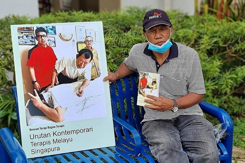 BUKU TERAPI MELAYU: Encik Saini Salleh, seorang mantan wartawan Berita Harian, bersama poster buku 'Urutan Kontemporari Terapis Melayu Singapura' yang ditulis beliau. - Foto ihsan HAJI ABDUL LATIFF AHMAD