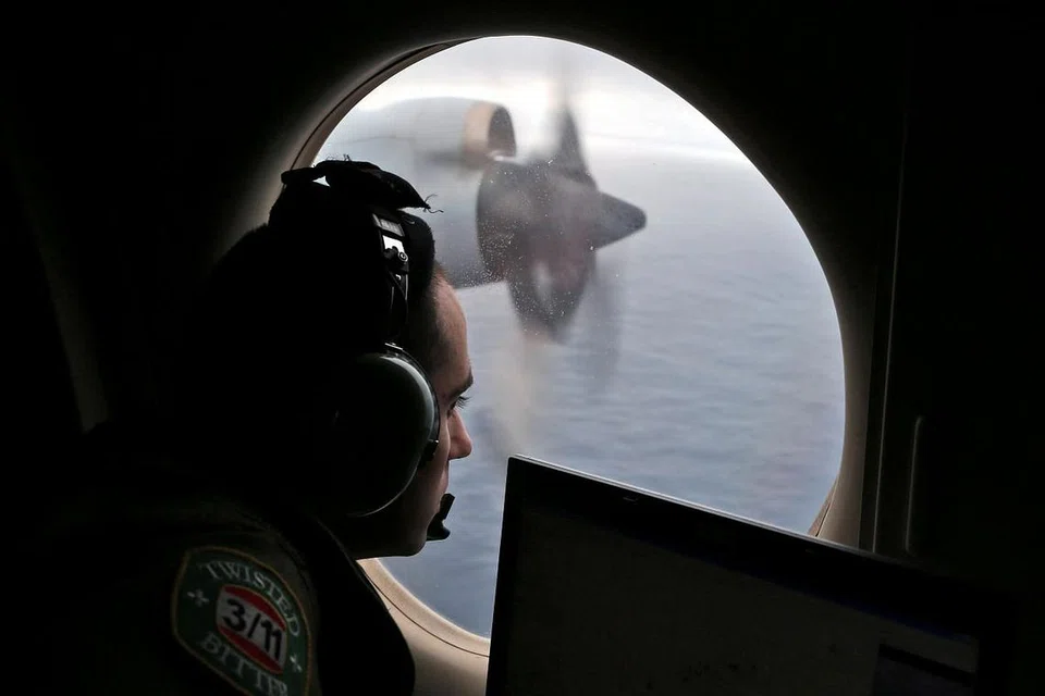 Pegawai penerbangan Angkatan Udara Diraja Australia melihat keluar dari pesawat AP-3C Orion semasa operasi mencari pesawat MH370 di Lautan Hindi pada Mac 2014. 