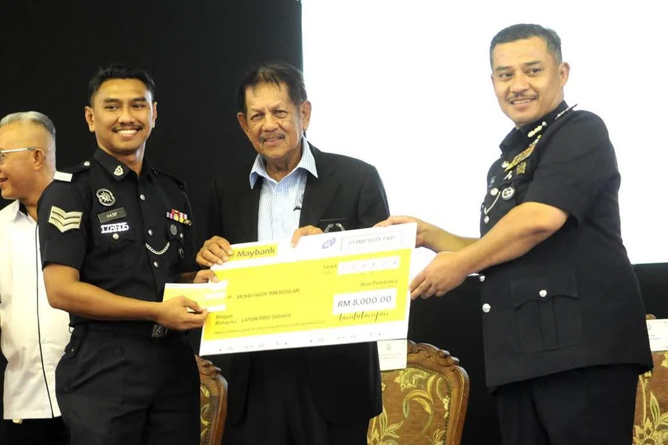 Presiden Persatuan Pegawai-Pegawai Kanan Polis Bersara Malaysia (RESPA), Datuk Meor Chek Hussien Mahayuddin (tengah) menyampaikan sumbangan kepada Sarjan Mohd Hasif Roslan (kiri) pada majlis Penyampaian Sumbangan Kepada anggota yang tercedera dalam insiden serangan Balai Polis Ulu Tiram di Ibu Pejabat Polis Daerah Kota Tinggi, Johor. 