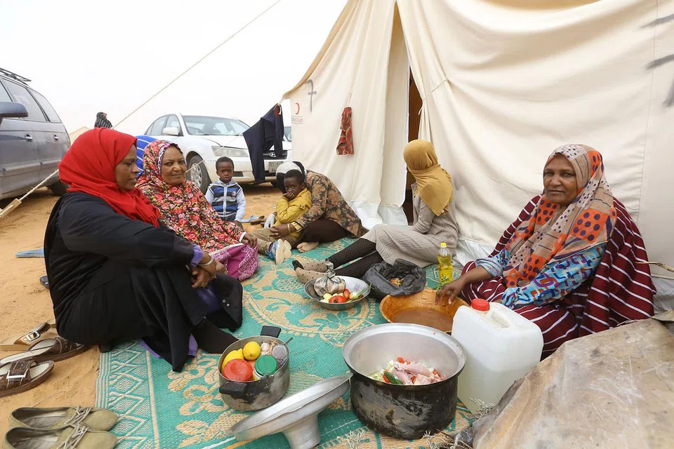 DIHALANG PULANG: Penduduk bandar Tawergha terdampar di padang pasir pada 10 Februari lalu. Mereka bergerak dengan tong gas masing-masing dan kayu yang digunakan untuk memanaskan badan dan memasak tanpa bekalan elektrik dan air. - Foto AFP
