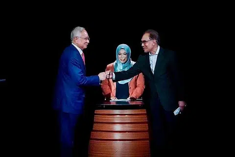 JULUNG-JULUNG KALI: Pendebat Datuk Seri Najib Razak (kiri) dan Datuk Seri Anwar Ibrahim bersentuhan genggaman sambil disaksikan oleh moderator Haslina AR Kamaluddin sebelum memulakan Program Debat Perdana di Matic, Kuala Lumpur. - Foto FAHMI FADZIL