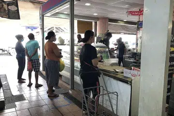 AMALKAN JARAK SELAMAT: Beberapa pelanggan lebih suka berbelanja dan membeli bekalan makanan di pasar kejiranan seperti yang dirakam di kedai daging Shakira di pasar Tampines Street 32 ini kerana ia bukan sahaja lebih selesa malah merupakan satu sikap bertanggungjawab dalam memastikan keselamatan semua pihak. - Foto BH oleh NATASHA MUSTAFA
