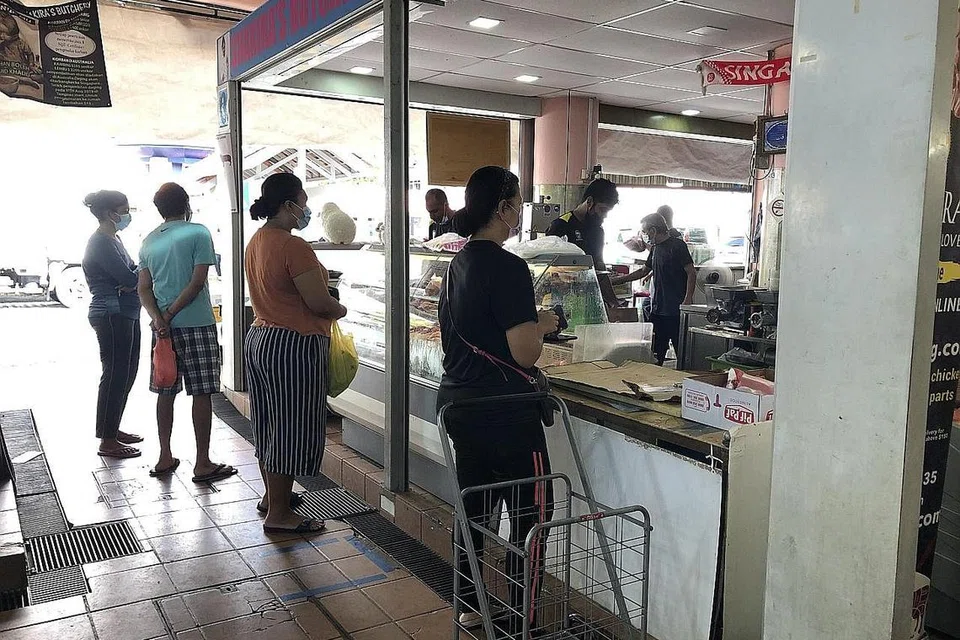 AMALKAN JARAK SELAMAT: Beberapa pelanggan lebih suka berbelanja dan membeli bekalan makanan di pasar kejiranan seperti yang dirakam di kedai daging Shakira di pasar Tampines Street 32 ini kerana ia bukan sahaja lebih selesa malah merupakan satu sikap bertanggungjawab dalam memastikan keselamatan semua pihak. - Foto BH oleh NATASHA MUSTAFA