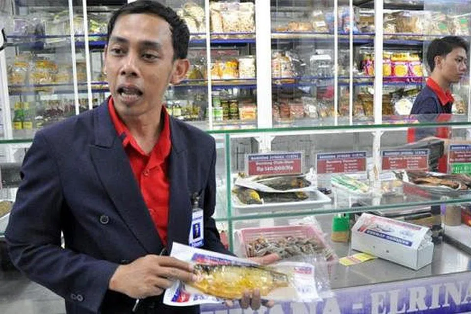 JADI HIDANGAN POPULAR: Encik Dhani menunjukkan antara ikan bandeng yang dijual di kedai Bandeng Juwana yang sering menjadi tumpuan pengunjung setempat dan dari luar negara. 