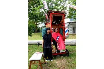 DIGAMIT MEMORI, TERFIKIR TEKNOLOGI: Cik Santi Ariestyowanti (kiri) dan Encik Dyatmiko 'Miko' Bawono yang menggelar diri mereka Indieguerillas, menghasilkan salun rambut bergerak yang dipanggil 'Goyang Cukur' bagi membolehkan pengunjung mengimbas kenangan lama di samping memikirkan tentang betapa pesatnya zaman sudah berubah. - Foto KHALID BABA