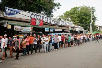 PERKEMBANGAN YANG DINANTIKAN: Penduduk di bandar Cotabato, selatan Filipina, beratur untuk mengundi dalam pungutan suara semalam.- Foto EPA-EFE