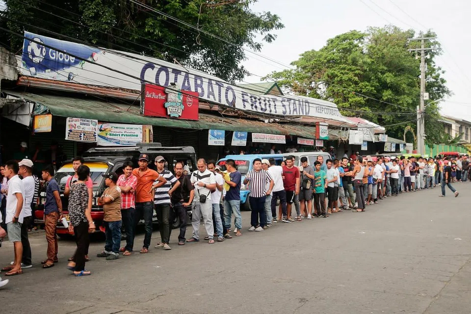 PERKEMBANGAN YANG DINANTIKAN: Penduduk di bandar Cotabato, selatan Filipina, beratur untuk mengundi dalam pungutan suara semalam.- Foto EPA-EFE