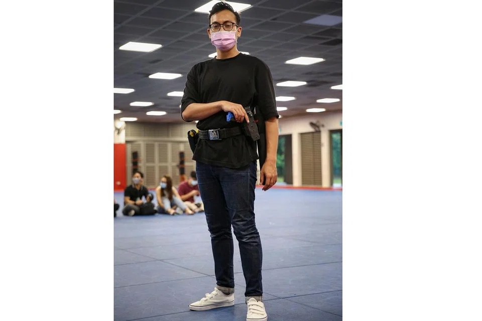 JADI 'POLIS' SEHARI: Wartawan Berita Harian, Harith Mustaffa, bersama pihak media lain diundang Pasukan Polis Singapura untuk menjalani program pendekatan media dengan mereka dapat merasakan secubit pengalaman mengendali senjata dan cara untuk menahan 'suspek.' - Foto BH oleh FELINE LIM
