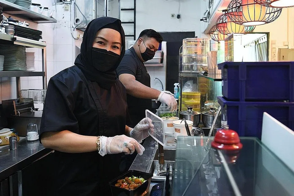 CUBA PELBAGAI PROMOSI: Cik Noraini menawarkan promosi bagi menggalak pelanggan memesan makanan daripada Ginger Wok dan Le Fuse Cafe. - Foto BH oleh MOHD KHALID BABA 