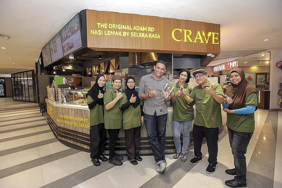 TETAP TERJEJAS: Encik Abdul Malik Hassan (tengah) berkata perniagaannya mengalami kerugian sekitar 50 peratus walaupun dengan khidmat penghantaran makanan yang diteruskan. Foto ini diambil pada April 2019. - Foto fail