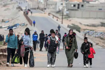 Rakyat Palestin meninggalkan kawasan tempat mereka berlindung dekat Hospital Al-Shifa di Bandar Gaza, selepas kawasan hospital tersebut menjadi sasaran pengeboman tentera Israel pada lewat Mac.