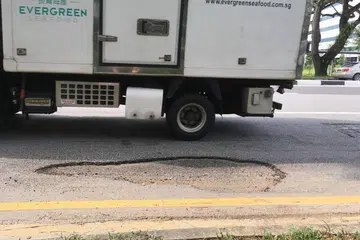 JALAN BERLUBANG KIAN BANYAK KERANA HUJAN: Jalan berlubang di Kallang Avenue. - Foto BH oleh ALPHONSUS CHERN 