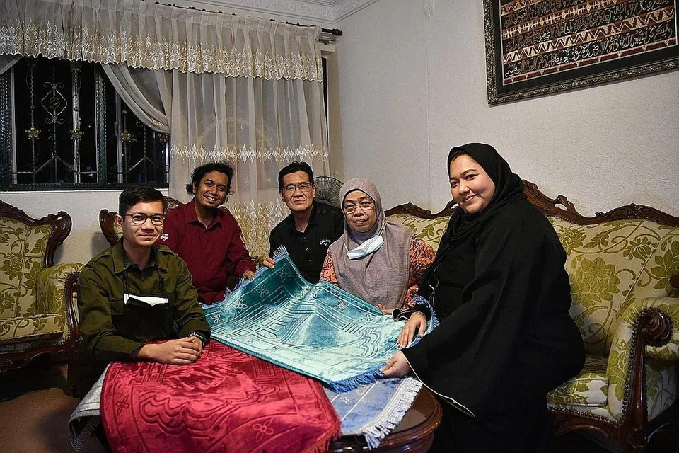 BERKONGSI REZEKI: Penggerak syarikat penganjur acara dan pengurus bakat MakBesar Pte Ltd yang diwakili (dari kiri) eksekutif jualan Ai'Dil, pengasas MakBesar, Firdaus Fid Faisal dan pengarah MakBesar, Haryani Othman, menggerakkan projek 'Gift-A-Sejadah' dan mendermakan sejadah permaidani yang dapat dimanfaatkan Encik Arsad Ahmad dan Cik Noor Omar. - Foto BH oleh ARIFFIN JAMAR