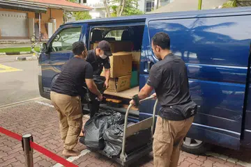 PERKHIDMATAN MUDAH: Pengasas Islamic Disposal & Cleaning Services (IDCS), Ustaz Muhammad Syahmi Arshad (kanan), dan adik Uztaz Syahmi, Encik Muhammad Hidayat Arshad (tengah) dan ahli pasukan IDCS, Encik Abd Rahim Ismail, sedang meletakkan barangan Islam yang dikumpul, ke dalam van mereka. Pelanggan tidak perlu risau untuk menghantar barangan ini ke mana-mana kerana IDCS akan datang untuk mengambilnya.
