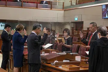 KOMITMEN UNTUK BERKHIDMAT: Encik Abdul Samad (kanan, tali leher merah) dan sebahagian NMP baru yang lain mengangkat sumpah di parlimen semalam. - Foto MCI