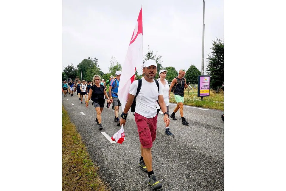 BERJALAN SAMBIL BAWA BENDERA SINGAPURA: Encik Rahmen bangga kerana berpeluang mewakili Singapura dalam acara The Walk of The World di Belanda.