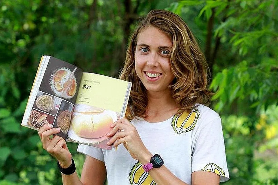 PAKAR DURIAN: Cik Lindsay Gasik bersama buku beliau, 'The Durian Tourist's Guide To Penang'. Antara durian yang beliau pernah buru ialah durian kura-kura, seperti yang terdapat di Kampung Selanyau, Bekenu Sibuti di Miri, Sarawak. Tidak seperti durian lain yang tumbuh di ranting pokok tinggi di atas, durian kura-kura tumbuh di batang pokok pada paras tanah. - Foto THE STAR