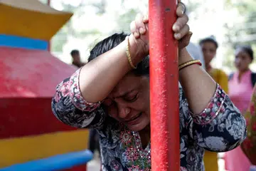 Seorang wanita menangis ketika menunggu maklumat terkini tentang keberadaan ahli keluarganya yang hilang, di luar Berek Maithali, sebuah pusat latihan tentera yang berfungsi sebagai pangkalan utama untuk mengangkut mangsa yang terselamat dari Rasuwa di Trishuli, daerah Nuwakot, Nepal.