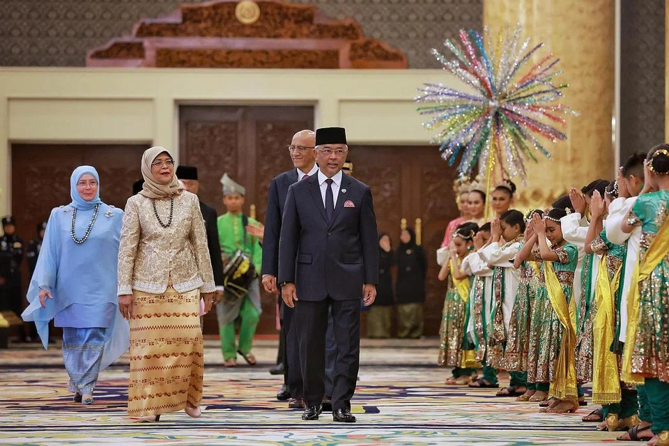 SAMBUTAN MEWAH: Presiden Halimah Yacob (dua dari kiri) diiringi Sultan Abdullah Ahmad Shah (tengah), Raja Permaisuri Agong Tunku Azizah Aminah Iskandariah (paling kiri) dan suami Puan Halimah, Encik Abdullah Alhabshee (belakang Agong) sebelum memasuki dewan bagi Majlis Santapan Negara. Mereka disambut dengan alunan kompang dan barisan penari kanak-kanak. - Foto ST