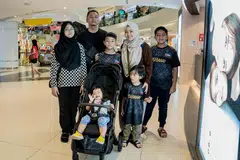 PERSIAPAN TAHUN DEPAN: Antara pengunjung di Tampines Mall ialah Cik Nurul Huda Hasbullah (dua dari kanan, bertudung) dan Encik Muhammad Faizal Zakaria (dua dari kiri, berdiri belakang) kededua berusia 41 tahun, yang mendapat barangan keperluan untuk lima anak mereka sebagai persiapan sempena pembukaan semula sekolah, sebelum kenaikan Cukai Barangan dan Perkhidmatan (GST) dari 8 peratus kepada 9 peratus pada 1 Januari.