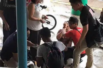 Wanita tua yang terjatuh dekat MRT Yishun dibantu kakitangan SAF yang tidak bertugas. Gambar ASHRAF ALI KHAN