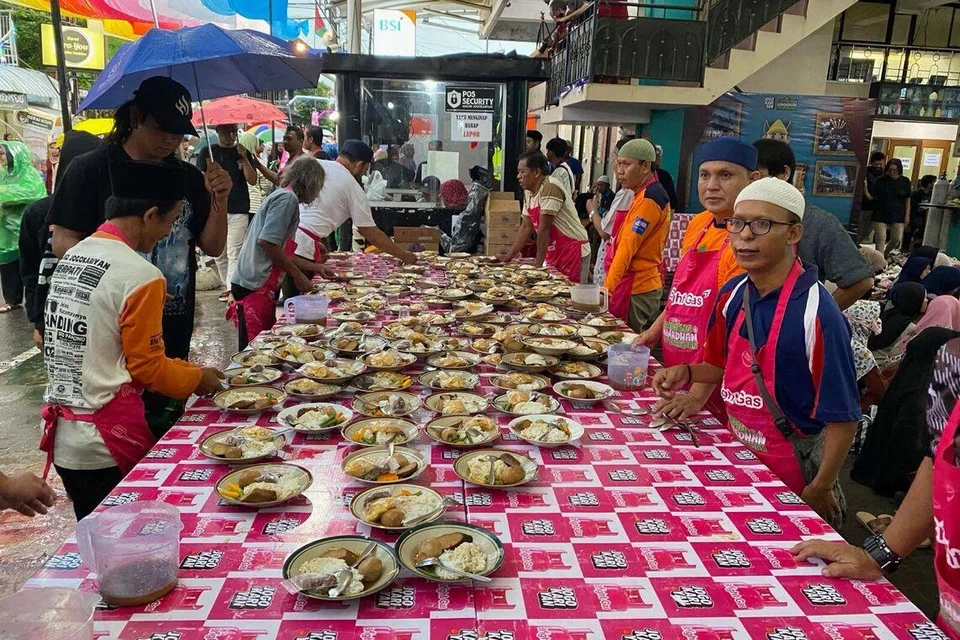 Sukarelawan dan penduduk Kampung Jogokariyan di Yogyakarta, Indonesia, mengagihkan hidangan iftar percuma yang disediakan oleh pihak masjid kepada jemaah dan pengunjung yang datang untuk merasai tradisi tahunan tersebut pada 28 Februari 2026.