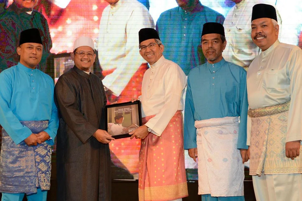 BUKU RAKAM PENCAPAIAN: (Dari kiri) Pengerusi MTTQ 2018, Haji Abdul Rahim Mawasi; Mufti Dr Mohamed Fatris Bakaram; Dr Yaacob Ibrahim; Ketua Eksekutif Muis, Haji Abdul Razak Maricar; dan anggota Jawatankuasa Pemandu Al-Quran, Haji Arzami Salim; melancarkan buku berjudul 'Jejak Insan, Semarak Al-Quran - Menjejak Sejarah Perkembangan 5 Dekad Musabaqah Tilawah dan Tahfiz Al-Quran Di Singapura' semalam. - Foto MUIS
