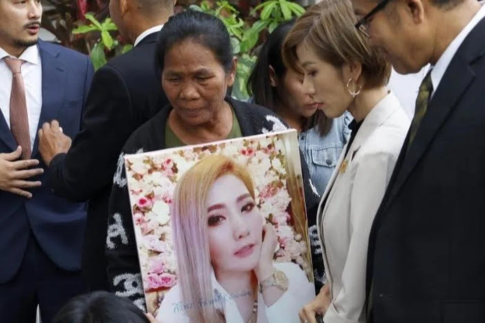 Cik Thongpin Kiatchanasiri, ibu kepada mangsa Cik Siriporn Kanwong, memegang gambar anak perempuannya ketika bercakap dengan media di luar Mahkamah Jenayah Bangkok pada 20 November