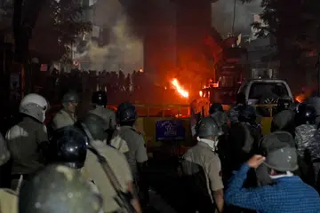 Anggota polis berkawal ketika beberapa kenderaan terbakar susulan pertempuran yang tercetus akibat tuntutan untuk merobohkan makam maharaja Mughal Aurangzeb, di Nagpur, India, pada 17 Mac 2025.