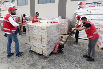 BANTUAN KEMANUSIAAN: Kakitangan Persatuan Bulan Sabit Merah Mesir menguruskan penghantaran bekalan kemanusiaan yang ditempatkan di sebuah gudang di Arish, Mesir pada 28 Oktober sebelum bekalan termasuk gandum dan barangan keperluan bagi kebersihan diri, digerakkan ke Jaluran Gaza menerusi sempadan Gaza. 