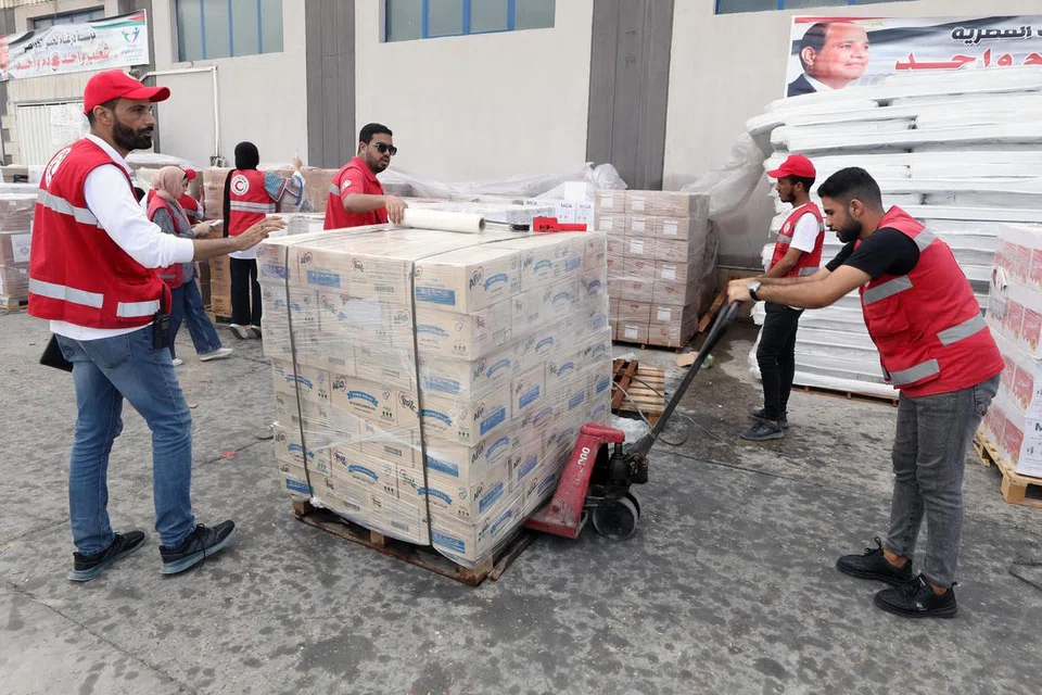 BANTUAN KEMANUSIAAN: Kakitangan Persatuan Bulan Sabit Merah Mesir menguruskan penghantaran bekalan kemanusiaan yang ditempatkan di sebuah gudang di Arish, Mesir pada 28 Oktober sebelum bekalan termasuk gandum dan barangan keperluan bagi kebersihan diri, digerakkan ke Jaluran Gaza menerusi sempadan Gaza. 