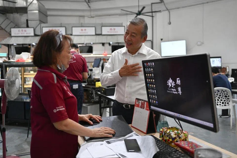 DEKATI MASYARAKAT: Usahawan Encik George Goh (kanan), yang berhasrat bertanding dalam Pilihan Raya Presiden, mengunjungi perusahaan sosial Dignity Kitchen pada Khamis, dan turut membantu membungkus makanan tengah hari untuk warga emas.