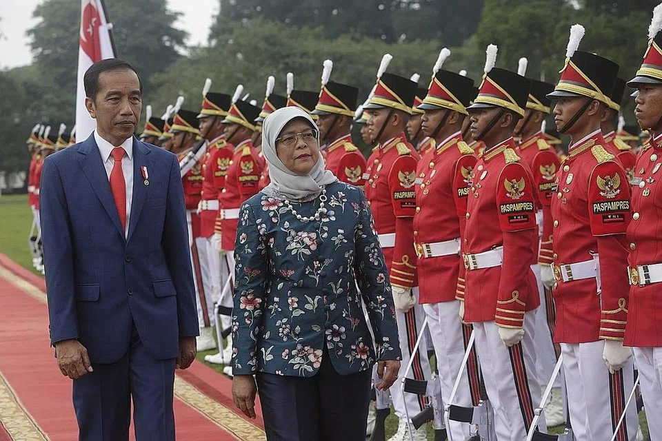 PERKUKUH HUBUNGAN: Presiden Halimah Yacob (kanan) seiringan dengan Presiden Indonesia Joko Widodo semasa memeriksa barisan kehormatan di Istana Bogor di Bogor, Indonesia Selasa lalu. - Foto EPA-EFE