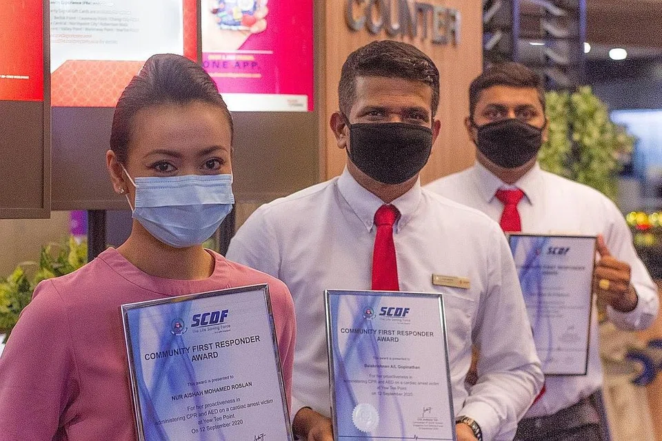 BERTINDAK CEPAT: Cik Aishah diiktiraf dengan Anugerah Responden Pertama Masyarakat oleh SCDF baru-baru ini kerana telah manfaatkan kemahiran CPR dan AED untuk menyelamatkan mangsa serangan jantung. Encik Balakrishnan (tengah) dan Encik Ram turut diiktiraf kerana membantu dalam kejadian tersebut. - Foto SCDF