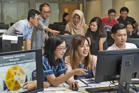 TINGKATKAN KEUPAYAAN: Pekerja Maybank seperti pegawai bank Cik Guslaini Mohamed (hijab coklat) ghairah diberi peluang untuk menambah kemahiran menerusi kursus pensijilan bagi masa depan yang baru dilancarkan. - Foto MAYBANK
