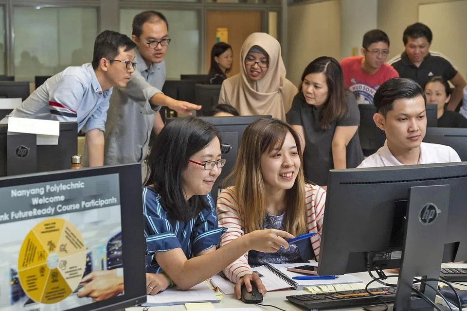 TINGKATKAN KEUPAYAAN: Pekerja Maybank seperti pegawai bank Cik Guslaini Mohamed (hijab coklat) ghairah diberi peluang untuk menambah kemahiran menerusi kursus pensijilan bagi masa depan yang baru dilancarkan. - Foto MAYBANK